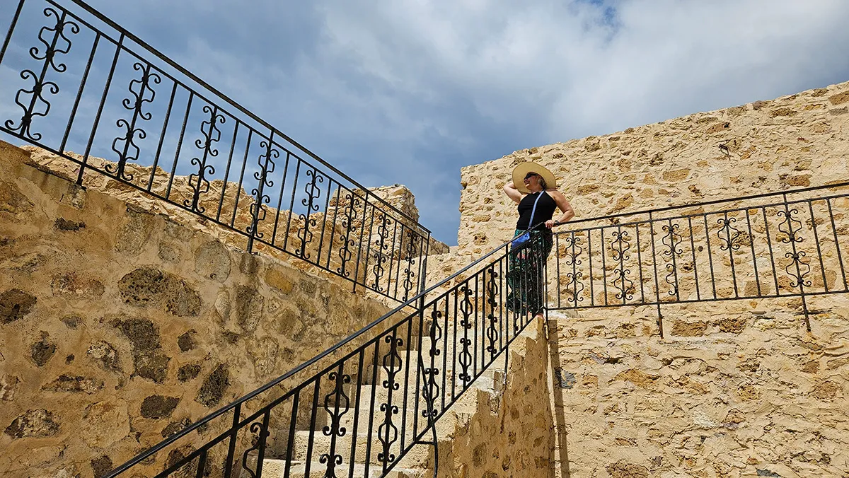 Escadas de pedra com corrimão decorativo no caminho do Farol de Chania.