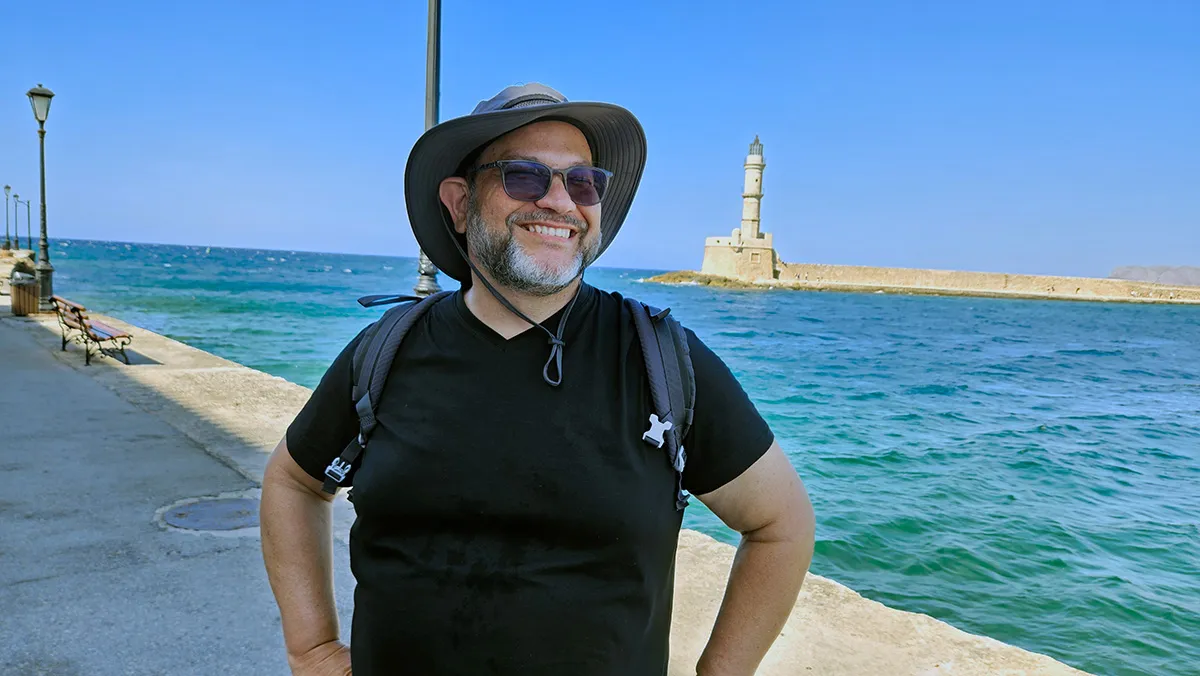 Homem sorridente perto do mar.