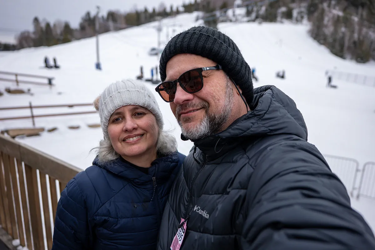 Casal sorrindo em ambiente nevado.