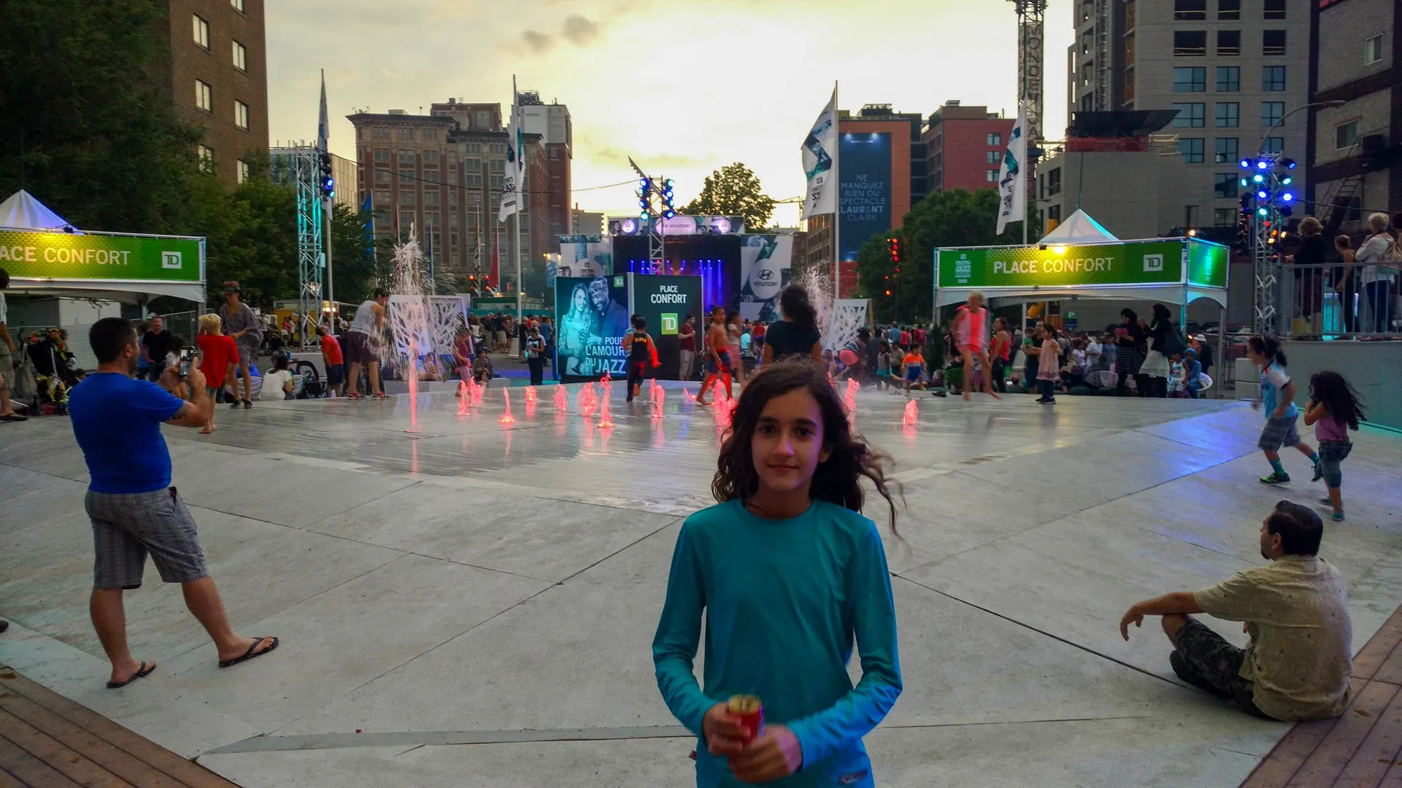 Criança brincando nas fontes de água da Place des Festivals durante o dia