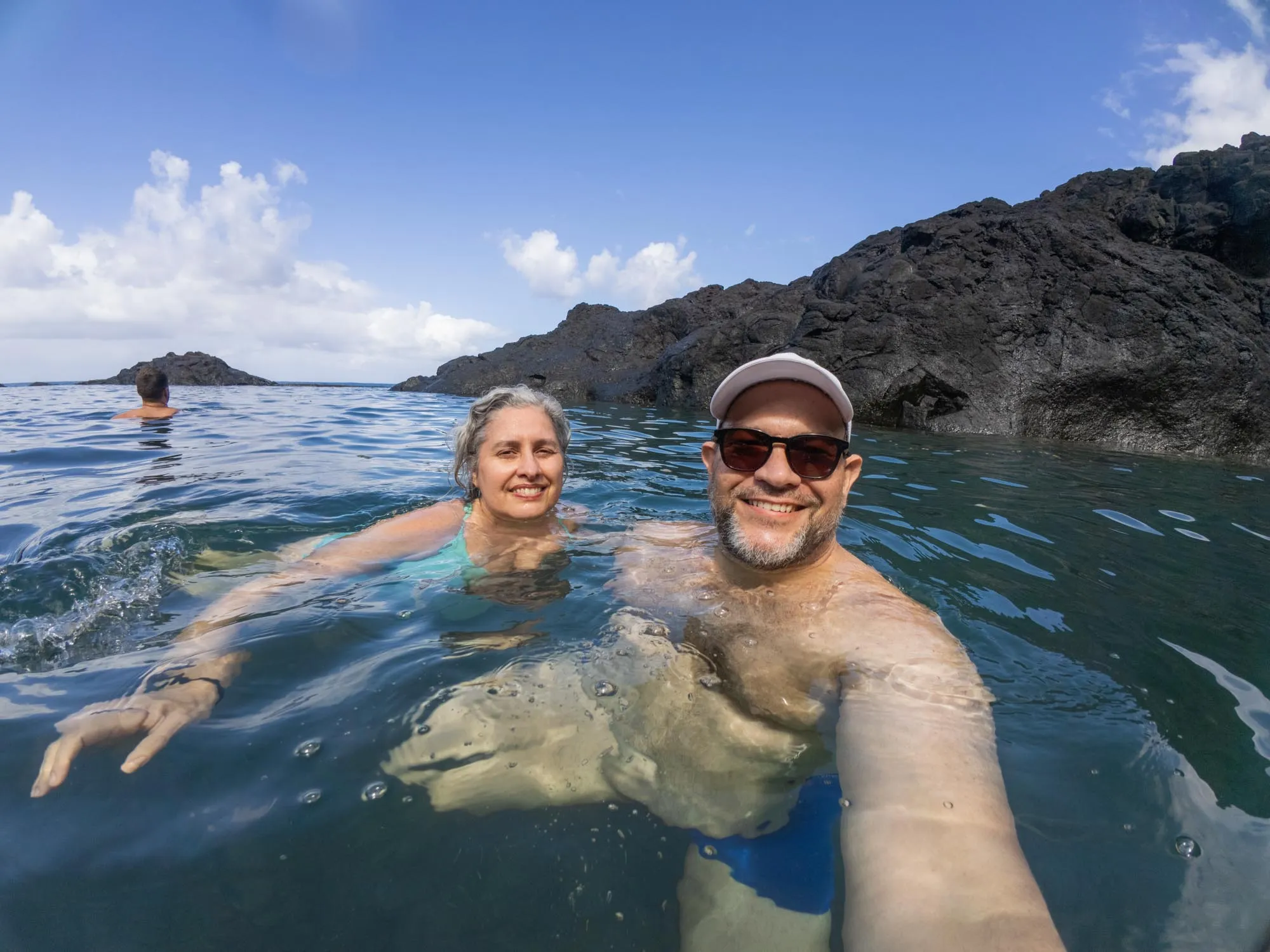 Formações de lava preta contornando as águas verdes das piscinas do Seixal
