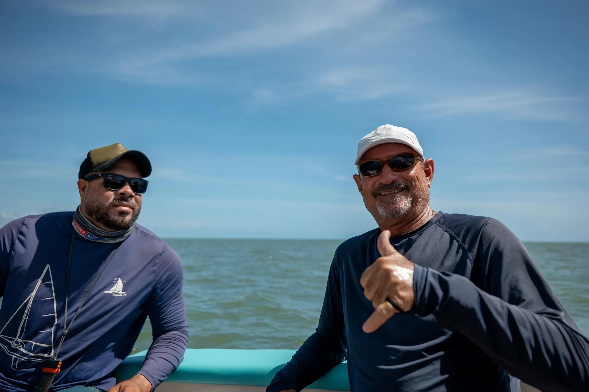 Pai e filho aproveitando o dia de sol a bordo do veleiro no litoral norte