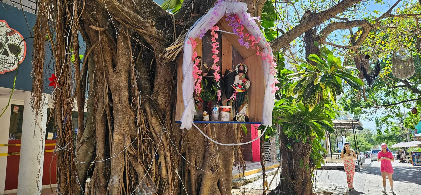 Letreiro comercial e pedestres caminhando por área de compras em Playa del Carmen