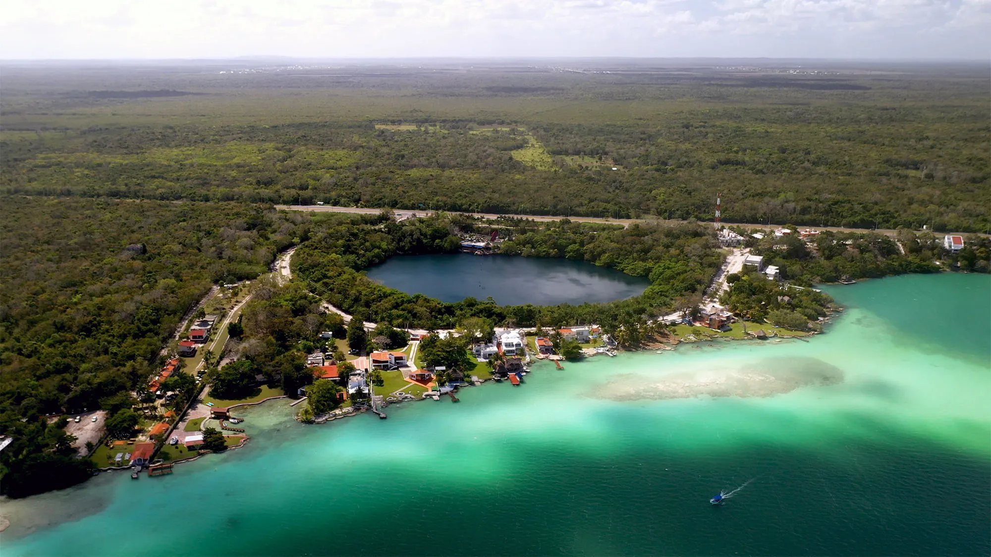 Cenote Azul com águas profundas cercado por vegetação em Bacalar