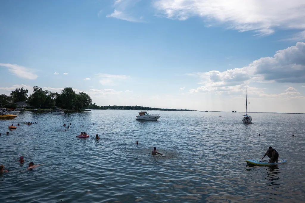 Banhistas e barcos ancorados no Lago Saint-François na Plage de Saint-Anicet