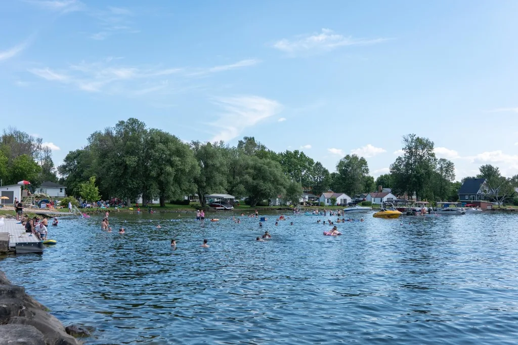 Banhistas se refrescando nas águas rasas e calmas de Saint-Anicet